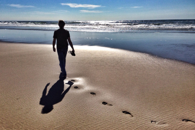 man walking at seashore